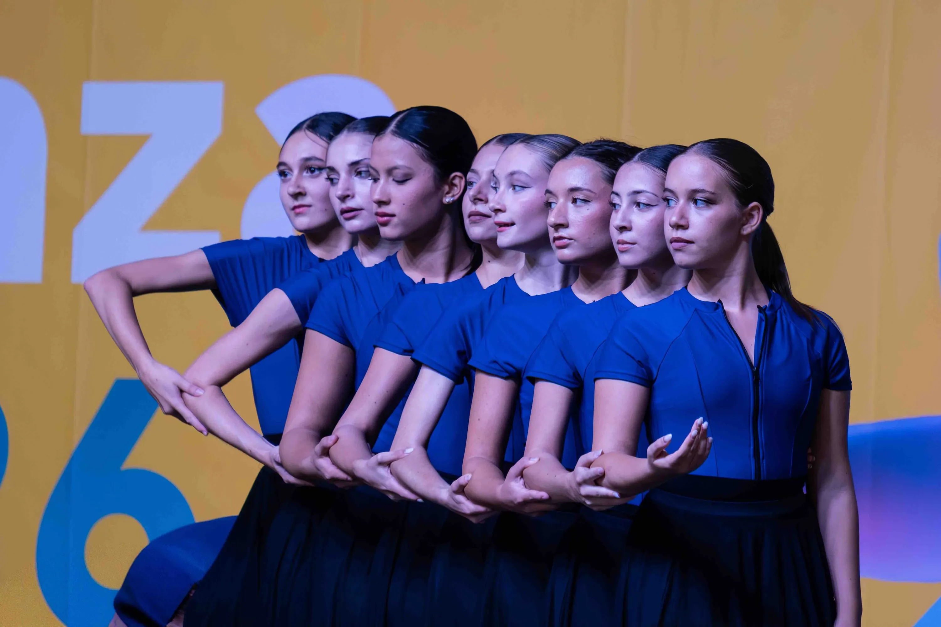 Fila di danzatrici in blu, i volti allineati di profilo