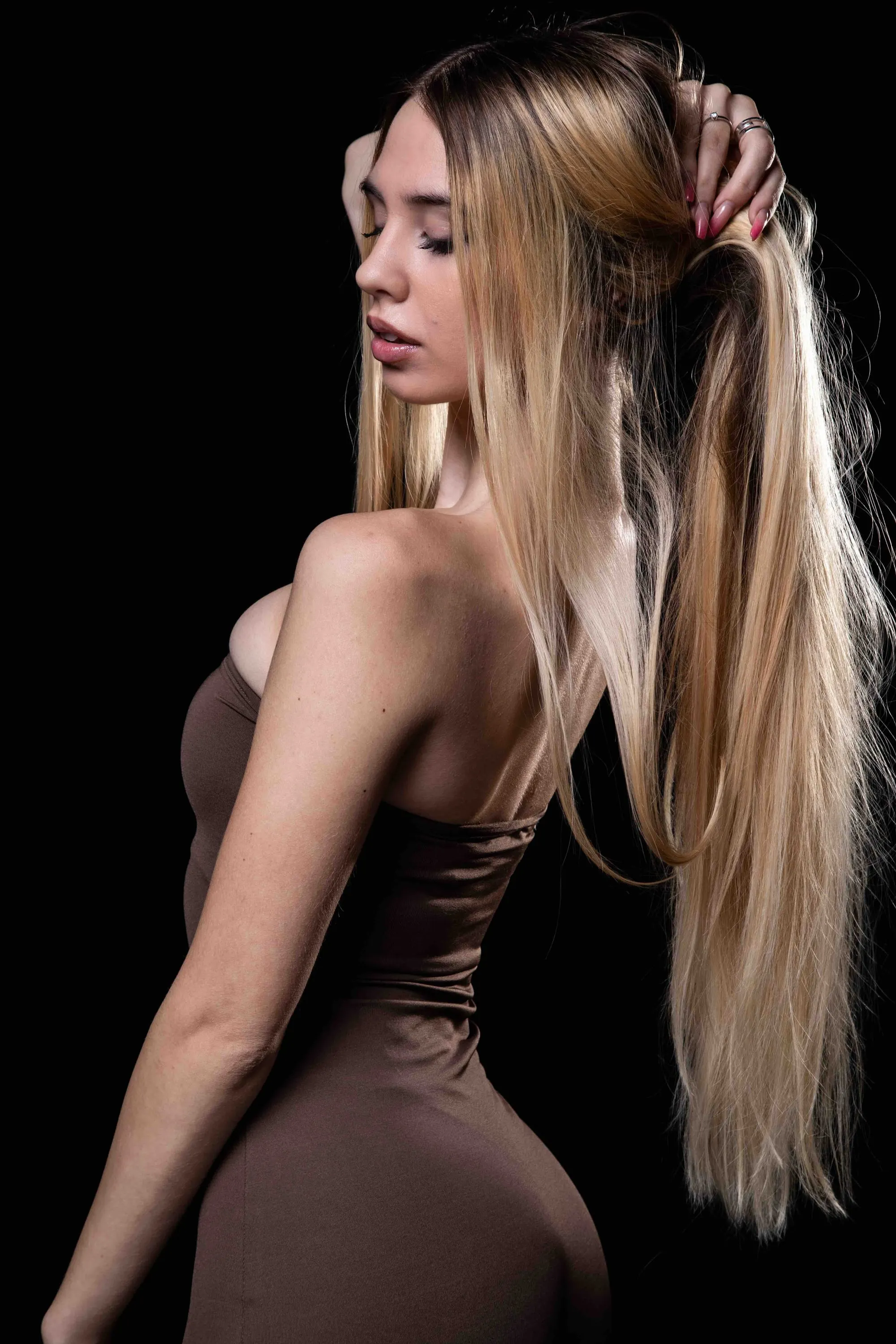 La ragazza bionda di spalle si raccoglie i capelli
