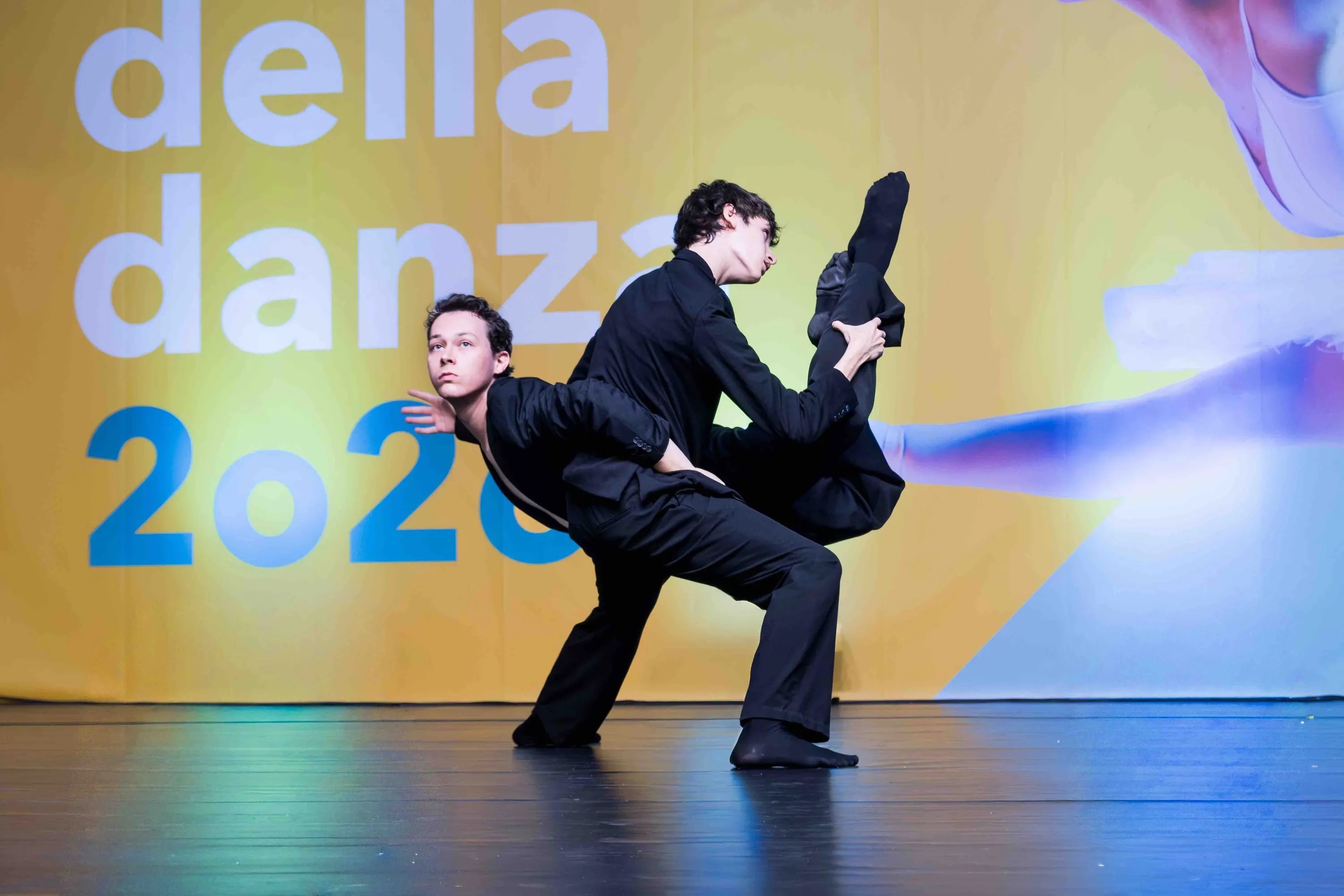 Due danzatori in nero, uno inclinato all'indietro sul compagno